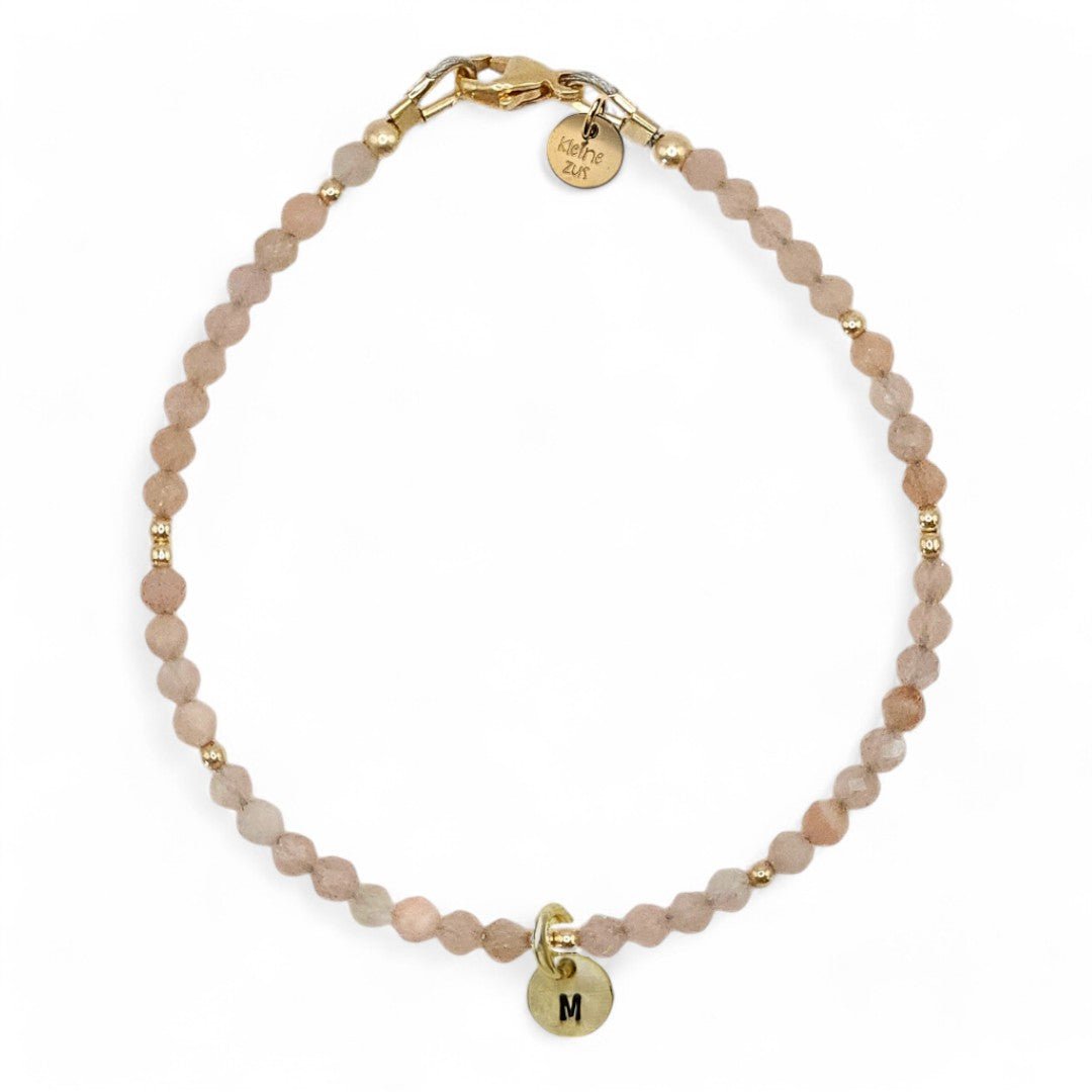 Gouden dames armband Annemae met zonnesteen, in het midden hangt een gouden initiaalbedel van 6mm