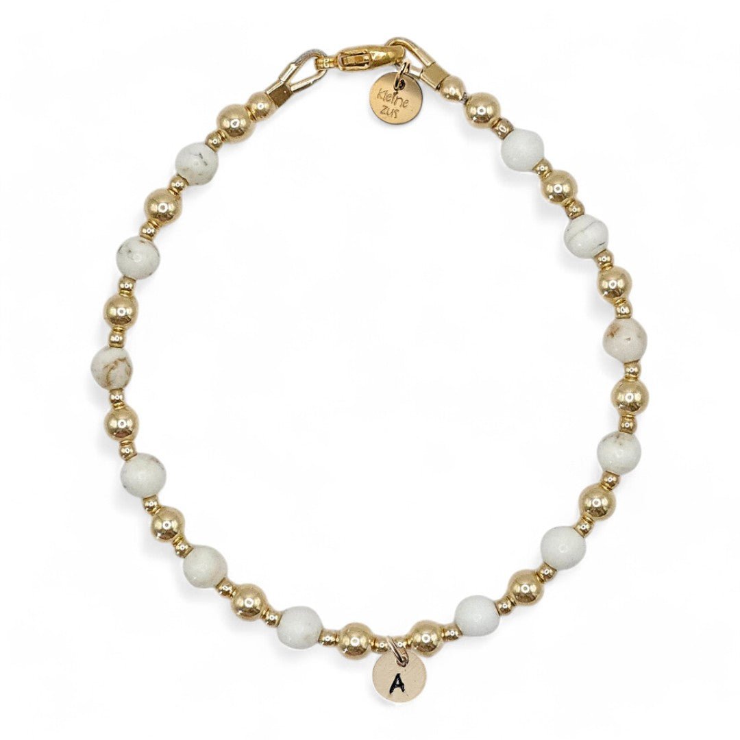 Gouden dames armband Evelien, 4mm gouden kraaltjes gecombineerd met magnesiet, in het midden van het armbandje hangt een gouden initiaalbedeltje van 6mm