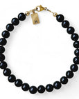 Gouden herenarmband Joeri met 6mm natuursteenkralen Obsidiaan, aan de slutiing hangt een gouden intiaalbedel