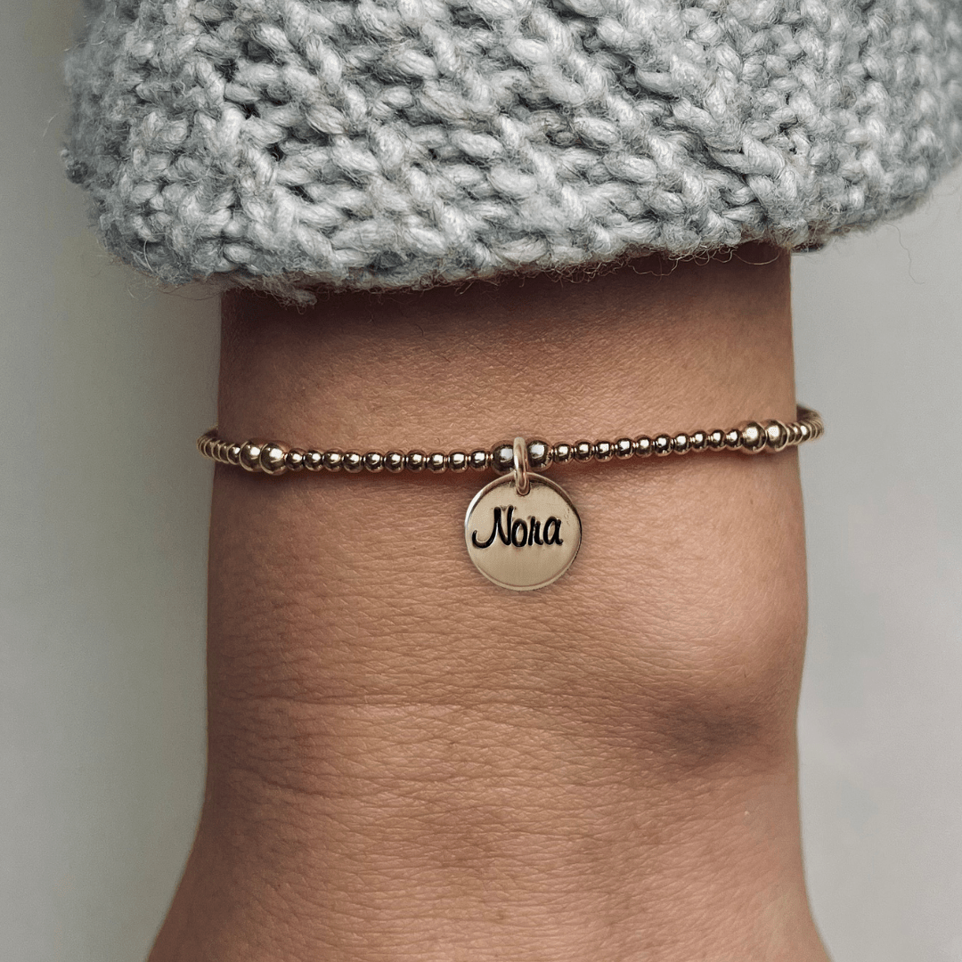 Armband met naam dames goud Pip
2mm gouden kraaltjes afgewisseld met 3mm, in het midden van de armband hangt een gouden naambedel van 10mm