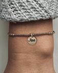 Armband met naam dames goud Pip
2mm gouden kraaltjes afgewisseld met 3mm, in het midden van de armband hangt een gouden naambedel van 10mm