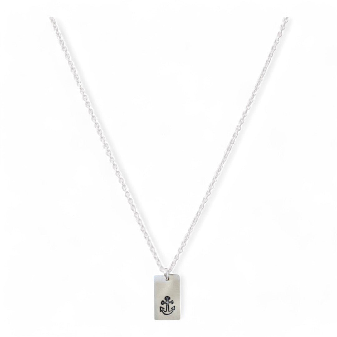 Zilveren dames ketting, aan de ketting hangt een zilveren tag met symbool