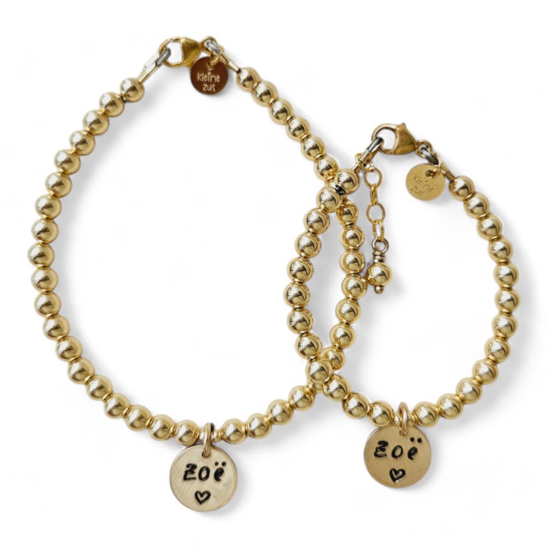 Moeder dochter armband goud Jill met 4mm kraaltjes, in het midden hangt een gouden naambedel van 10mm