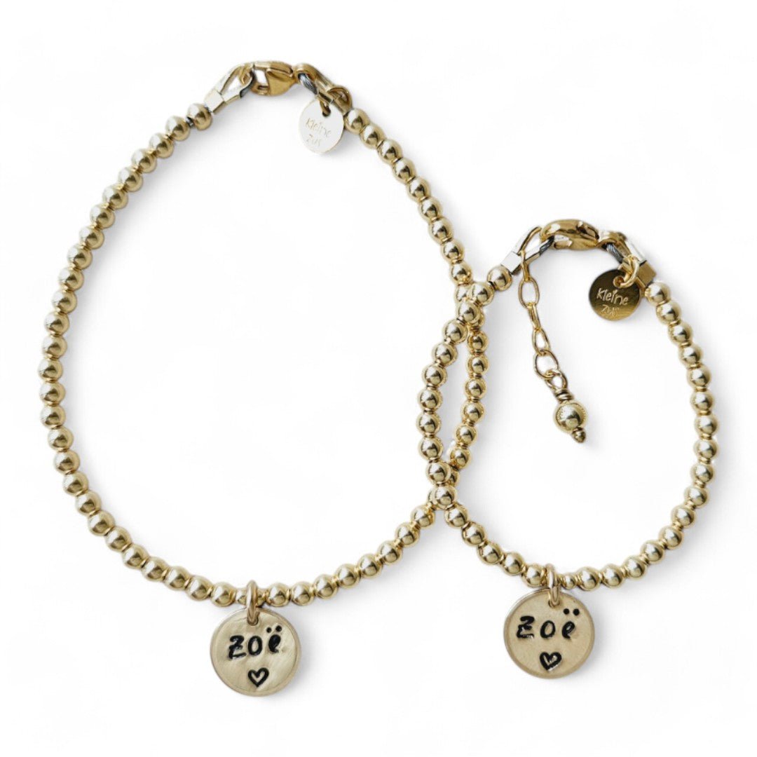 Moeder dochter armband goud met naam Juul met 3mm kraaltjes, in het midden hangt een gouden naambedel van 10mm
