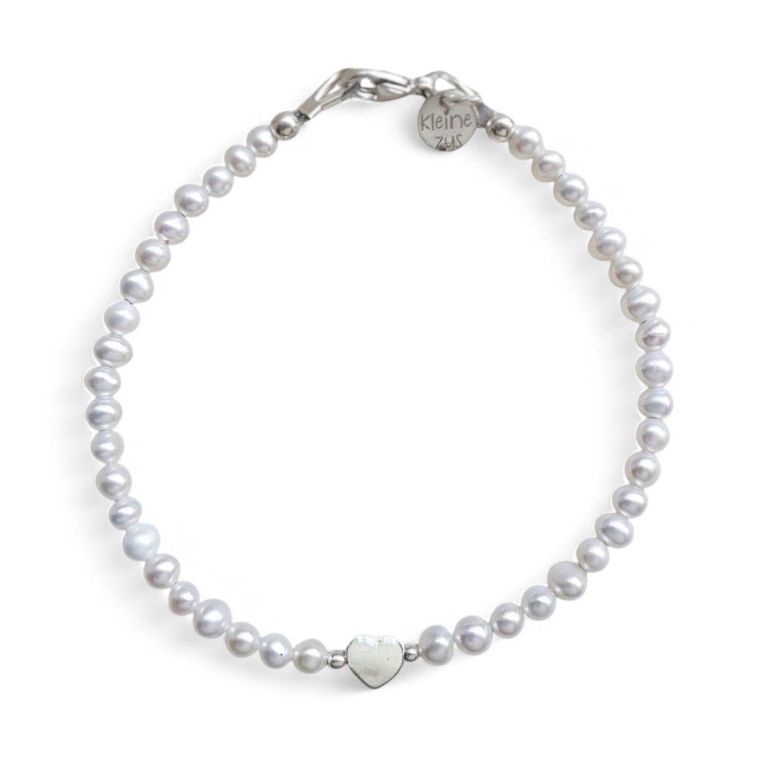 Zilveren dames armband met parels, in het midden zit een zilveren hartjeskraal