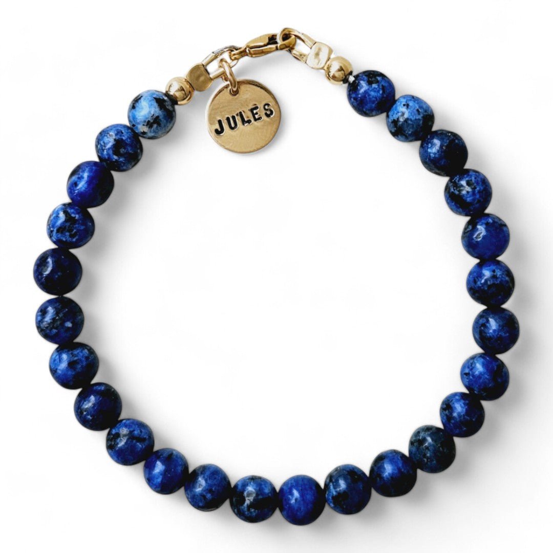 Gouden herenarmband Jort met 6mm natuursteenkralen blauwe kwarts, aan de sluiting hangt een gouden naambedel van 10mm