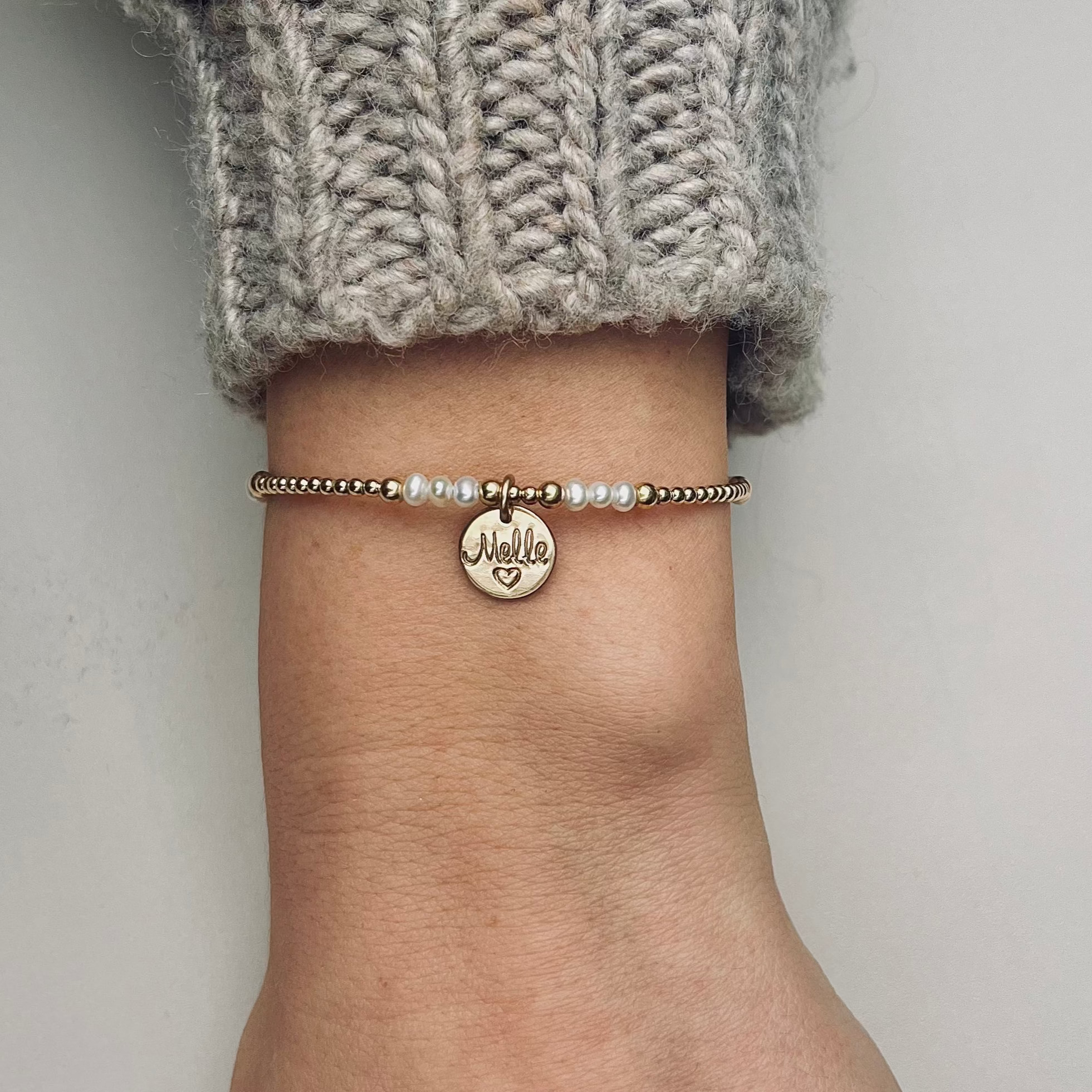 Armband met naam dames goud Nova
2mm gouden kalen gecombineerd met parel. In het midden van de armband hangt een gouden naambedel van 10mm
