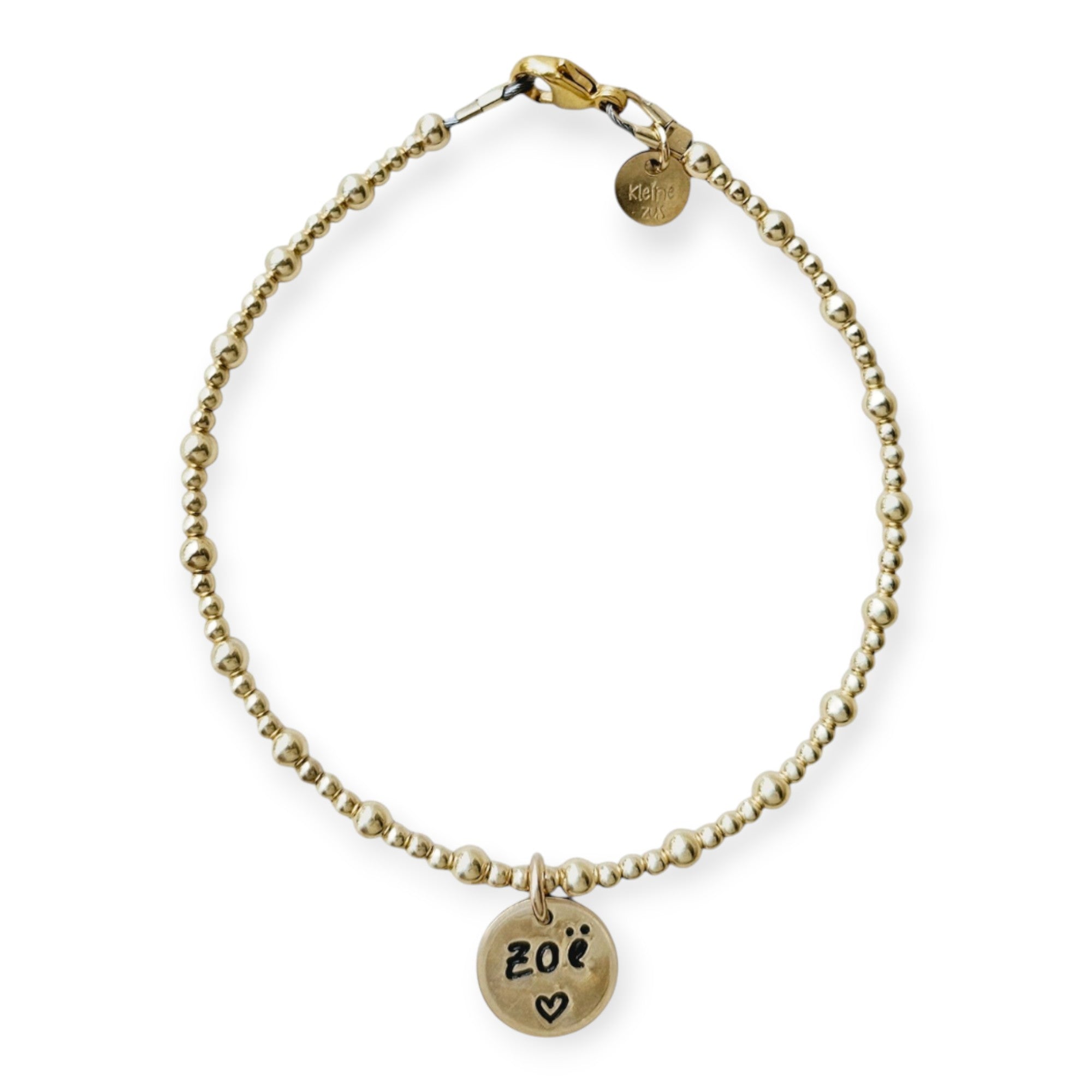 Armband met naam dames goud Sylvia
3 en 2 mm gouden kraaltjes gecombineerd, in het midden van de armband hangt een gouden naambedel van 10mm