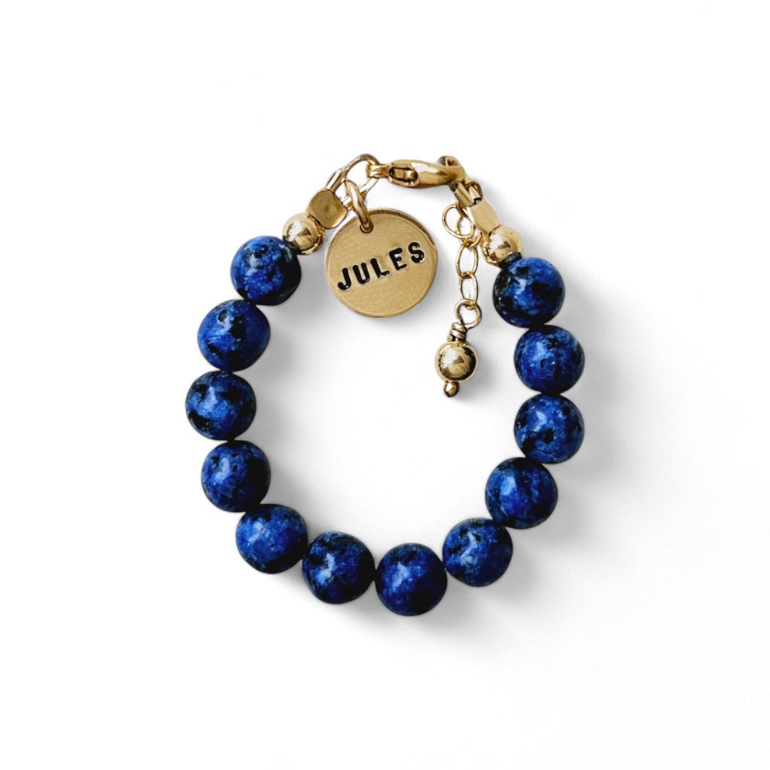 Gouden jongens armbandje Jort is gemaakt van 6mm natuursteenkralen blauwe kwarts, aan de sluiting hangt een gouden naambedel van 10mm