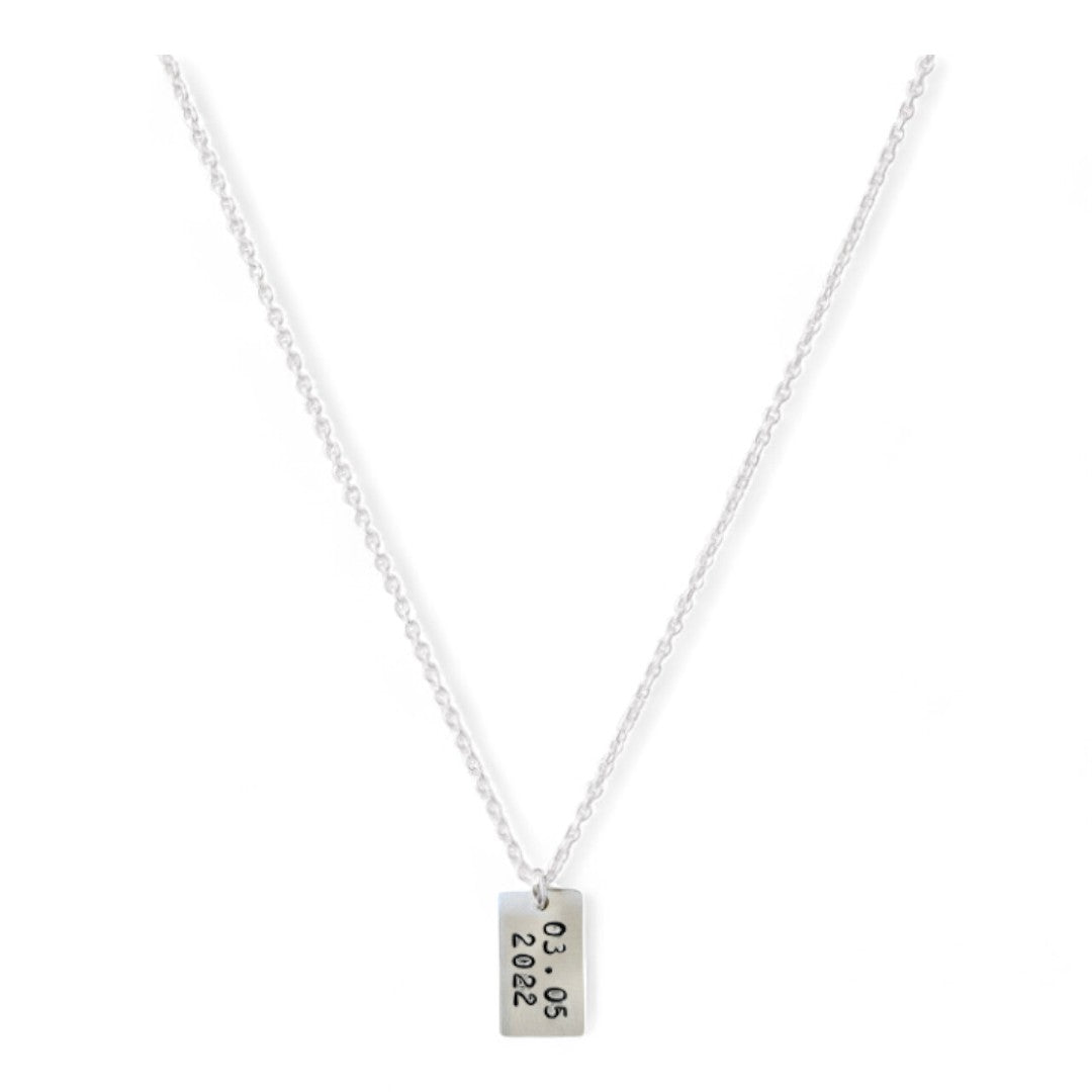 Zilveren ketting, aan de ketting hangt een zilveren tag